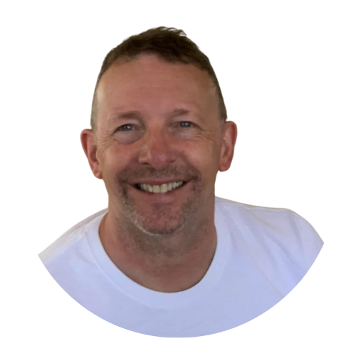 Portrait of Mark Bridge, Chair of the Sundowns Board of Trustees, smiling in a white t-shirt.